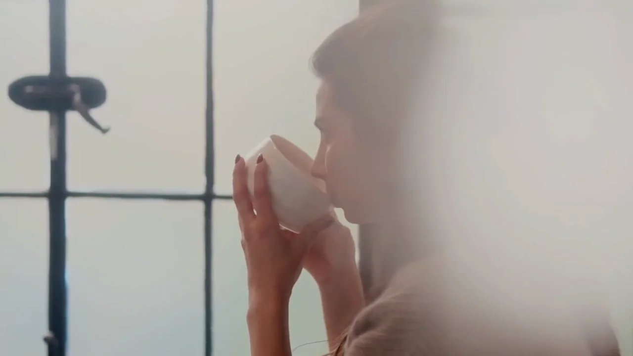 A woman at the table by the window at River Arts Club, tea in hand